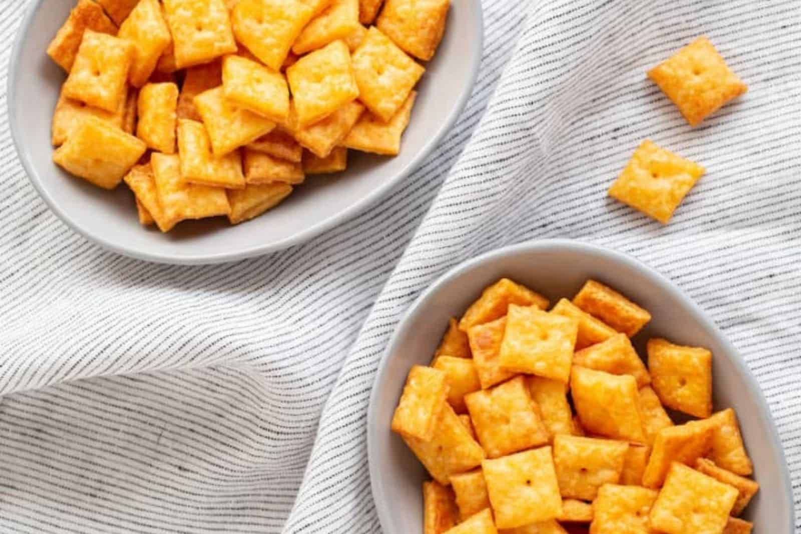 Cheez-Its in white bowls on a white tablecloth