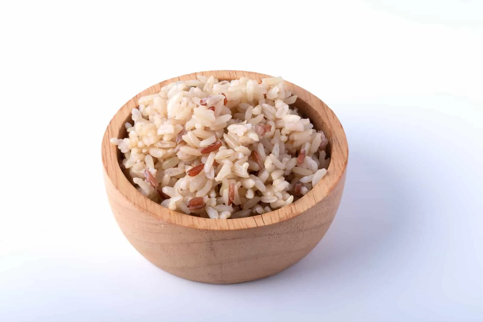Jasmine brown rice in wooden cup on white background