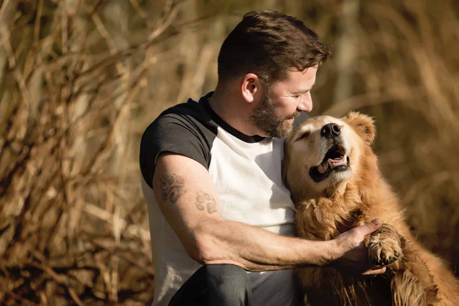 a man is playing with a golden retriever