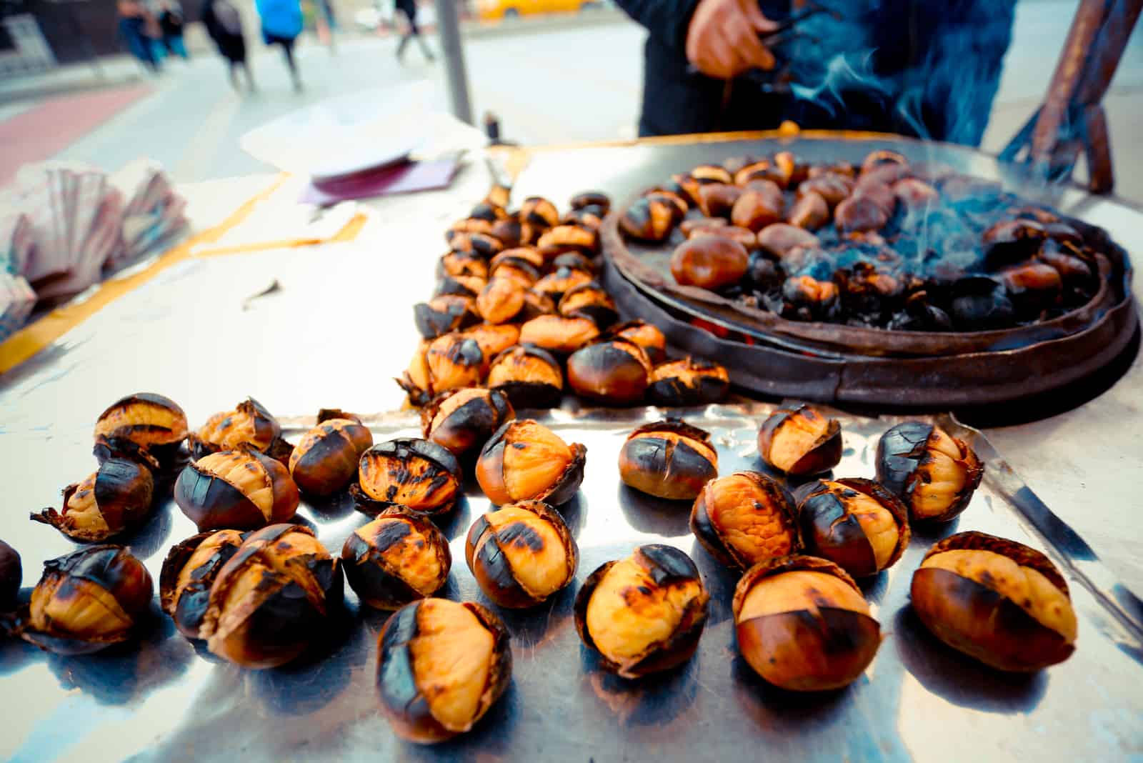 a man sells roasted chestnuts on the street