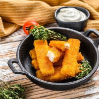 fish sticks on plate with mayo sauce on the side