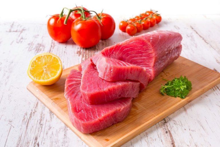 tuna fillet placed on a platter with tomatoe and lemon