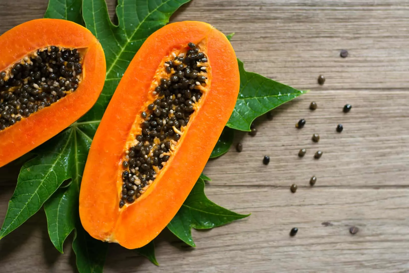 Slices of sweet papaya fruit on wooden background