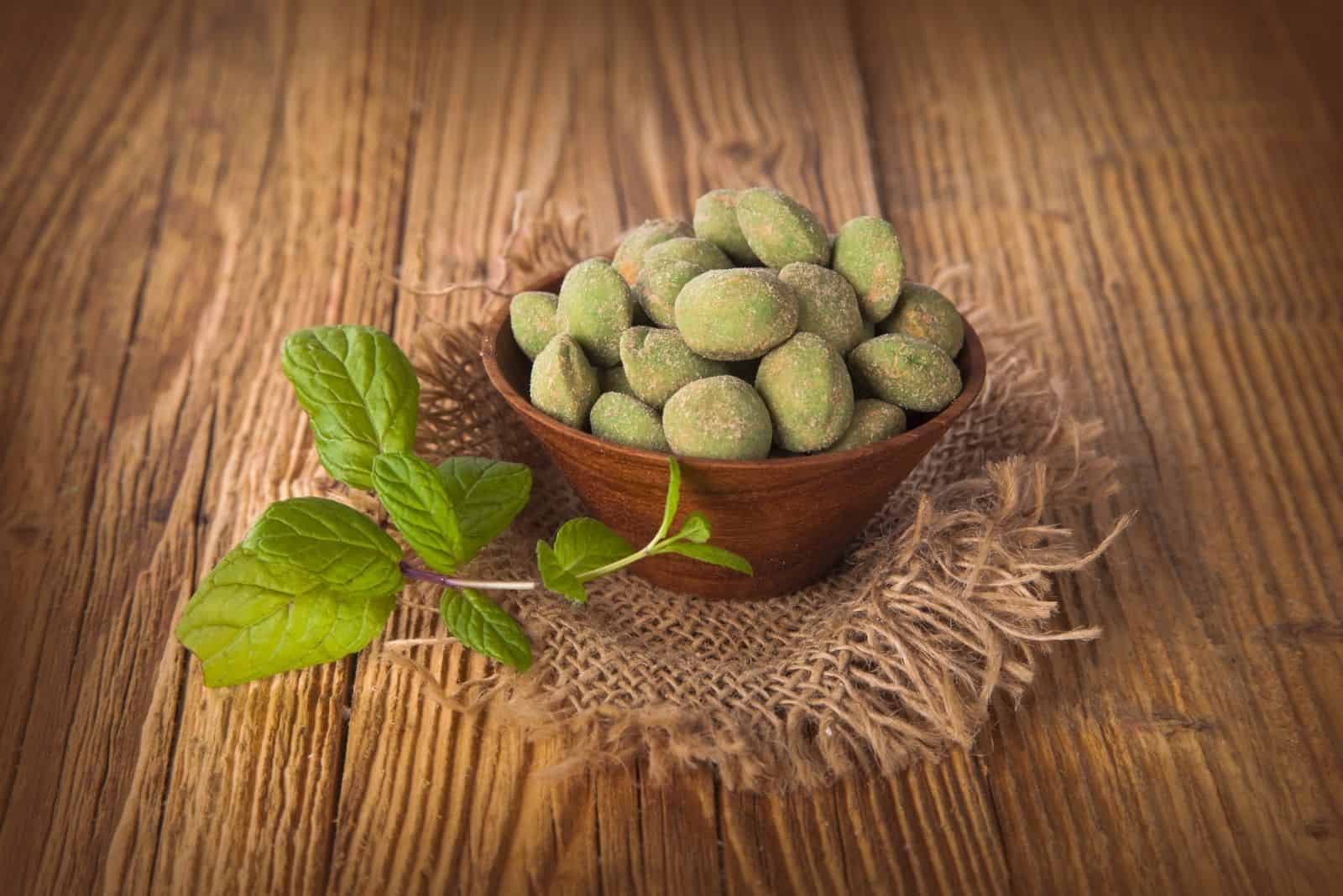 almond nuts wasabi on wooden bowl with mint leaves