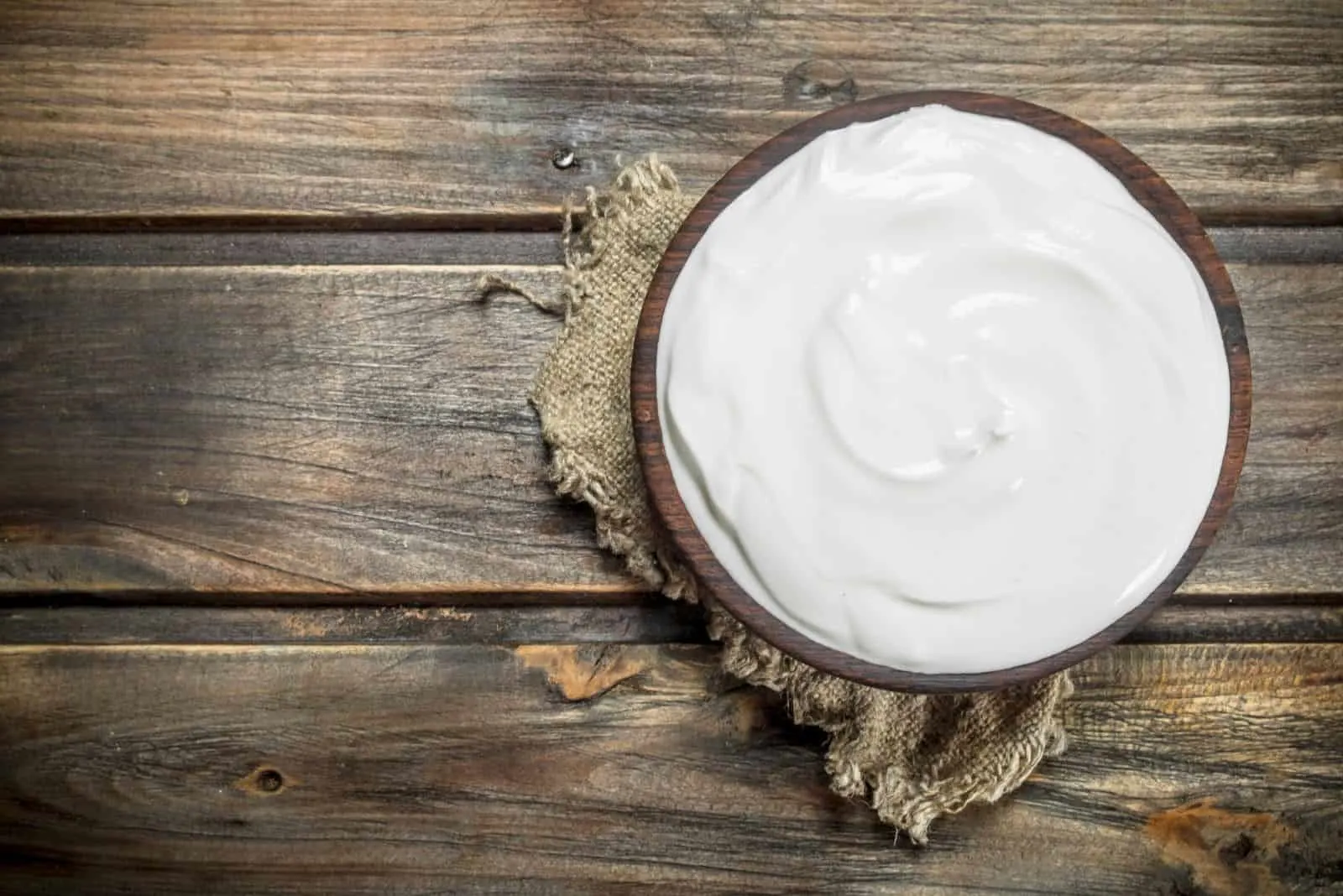 fresh sour cream in a bowl in a wooden table