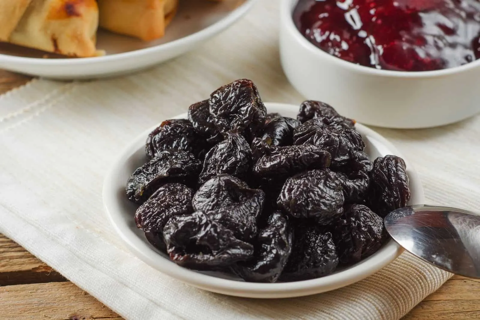 prunes in small plate and jam beside on the table