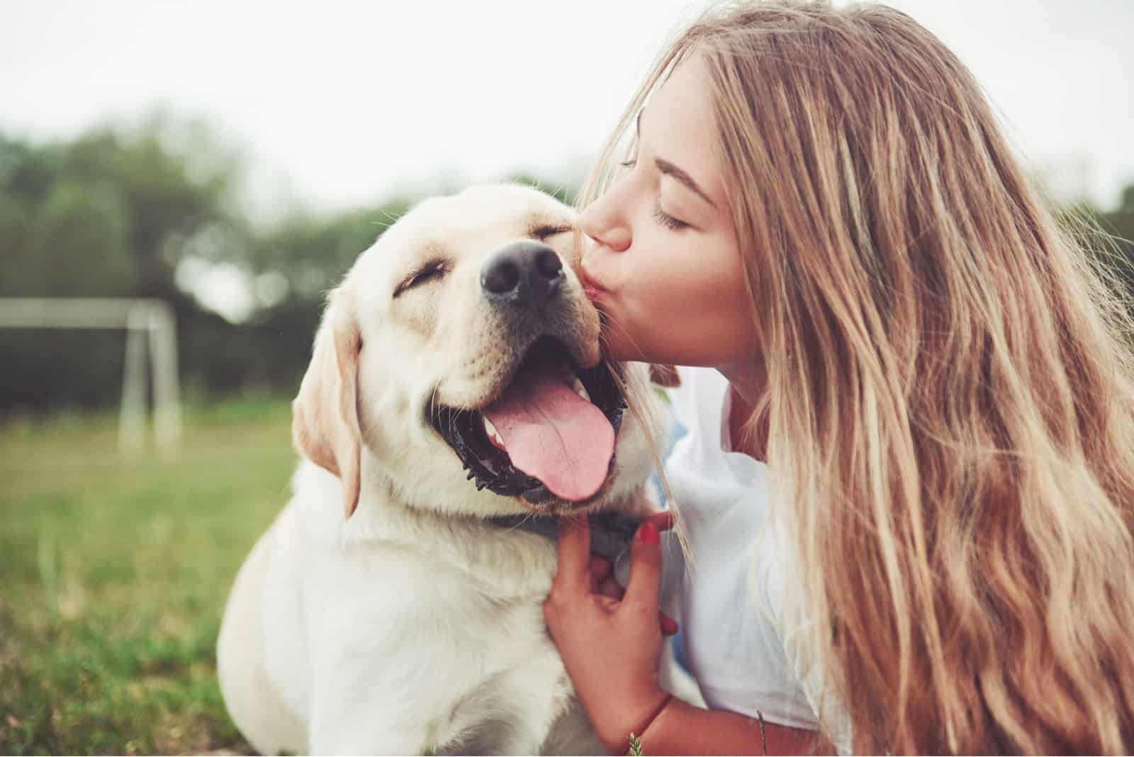 the girl kisses her dog in the muzzle