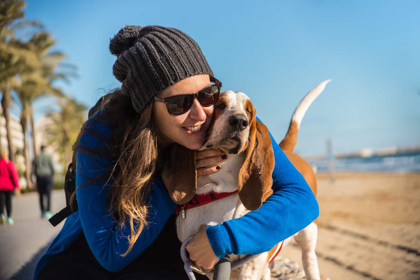 woman hugs basset hound