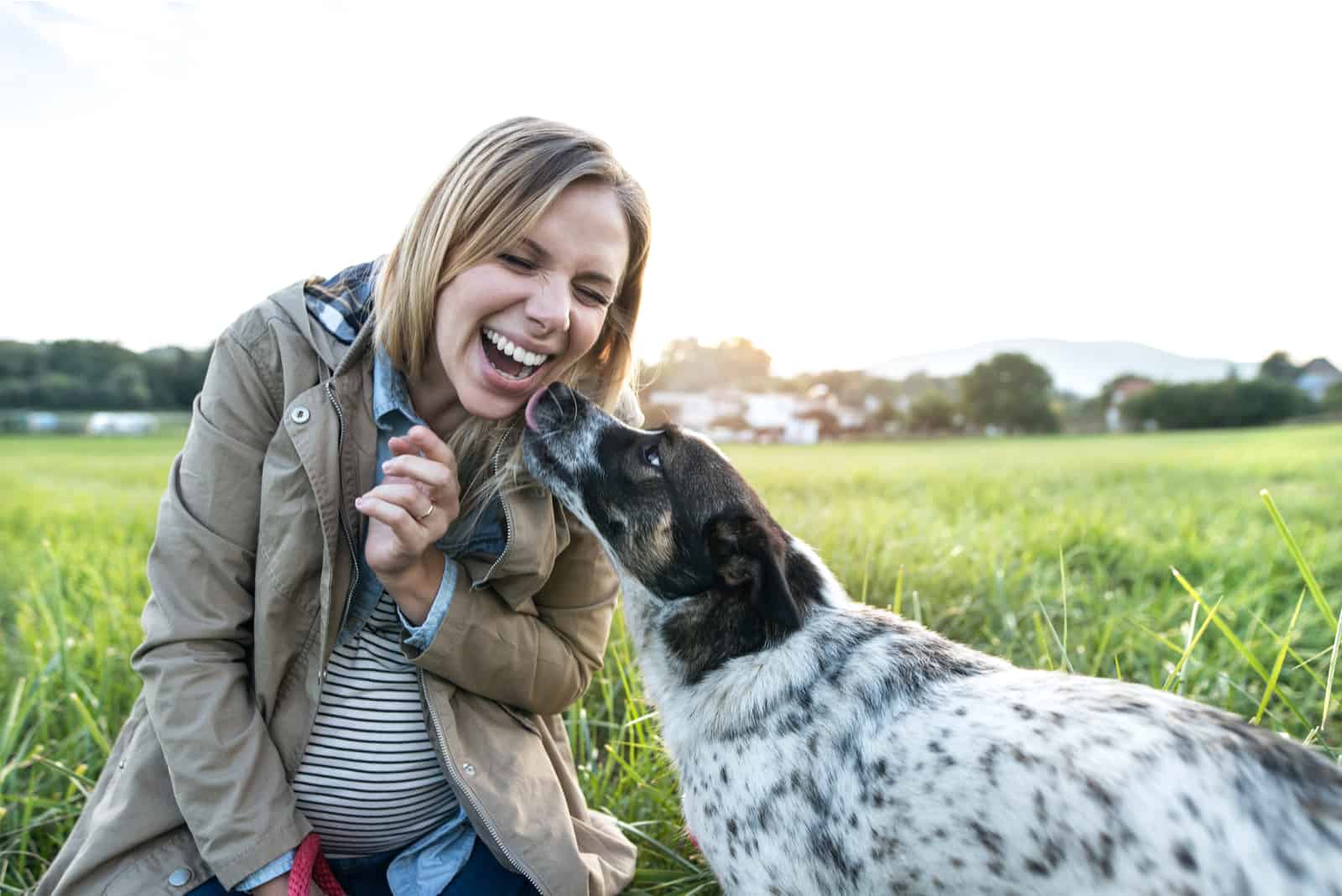 happy woman with dog in green sunny nature