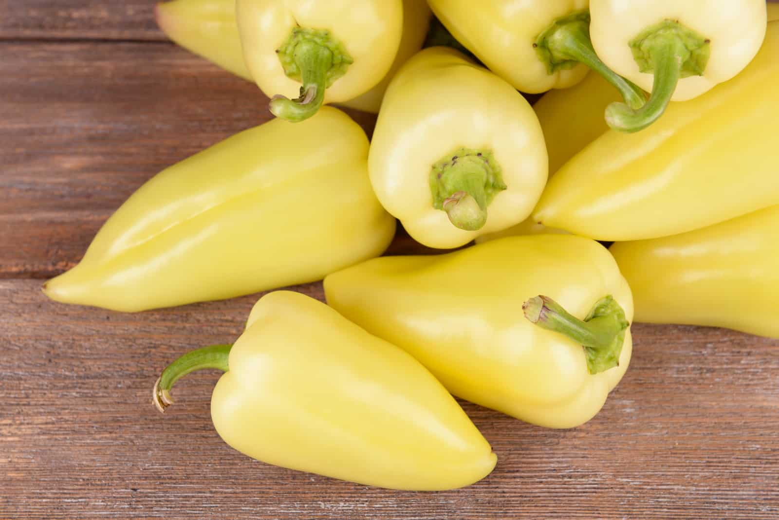 Yellow peppers on wooden background