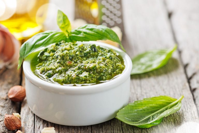 pesto sauce in a white bowl on top of the table