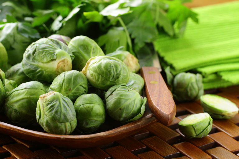 fresh raw brussels sprouts on a wooden table and knife