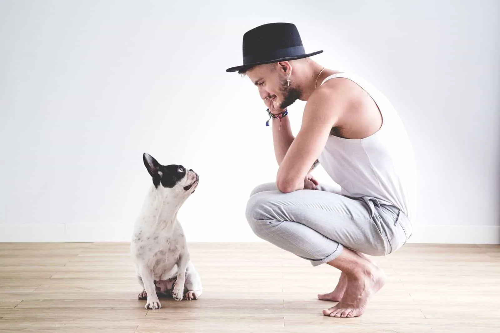 Hipster boy with hat chatting with his french Bulldog dog