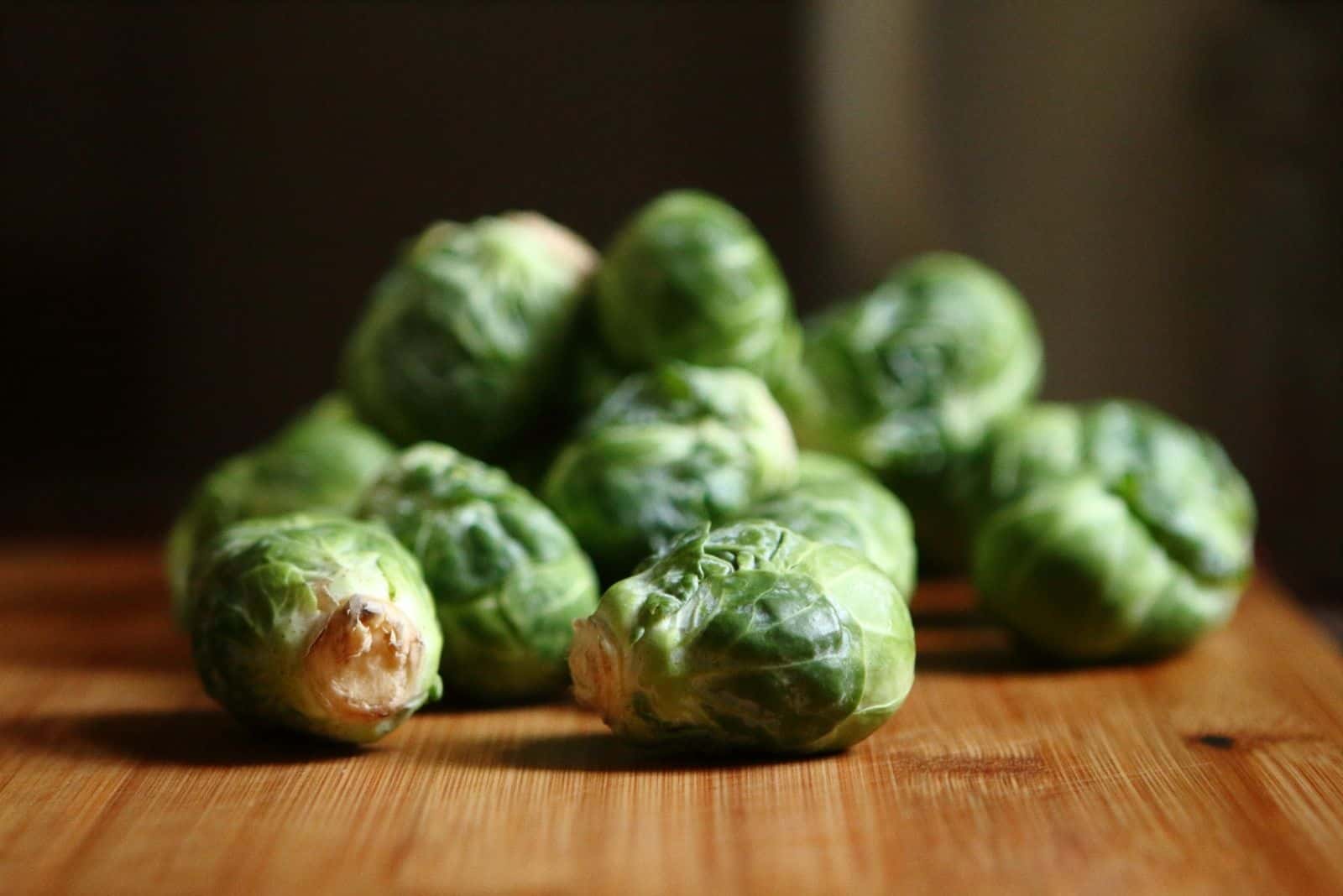 few brussel sprouts on top of the wooden table