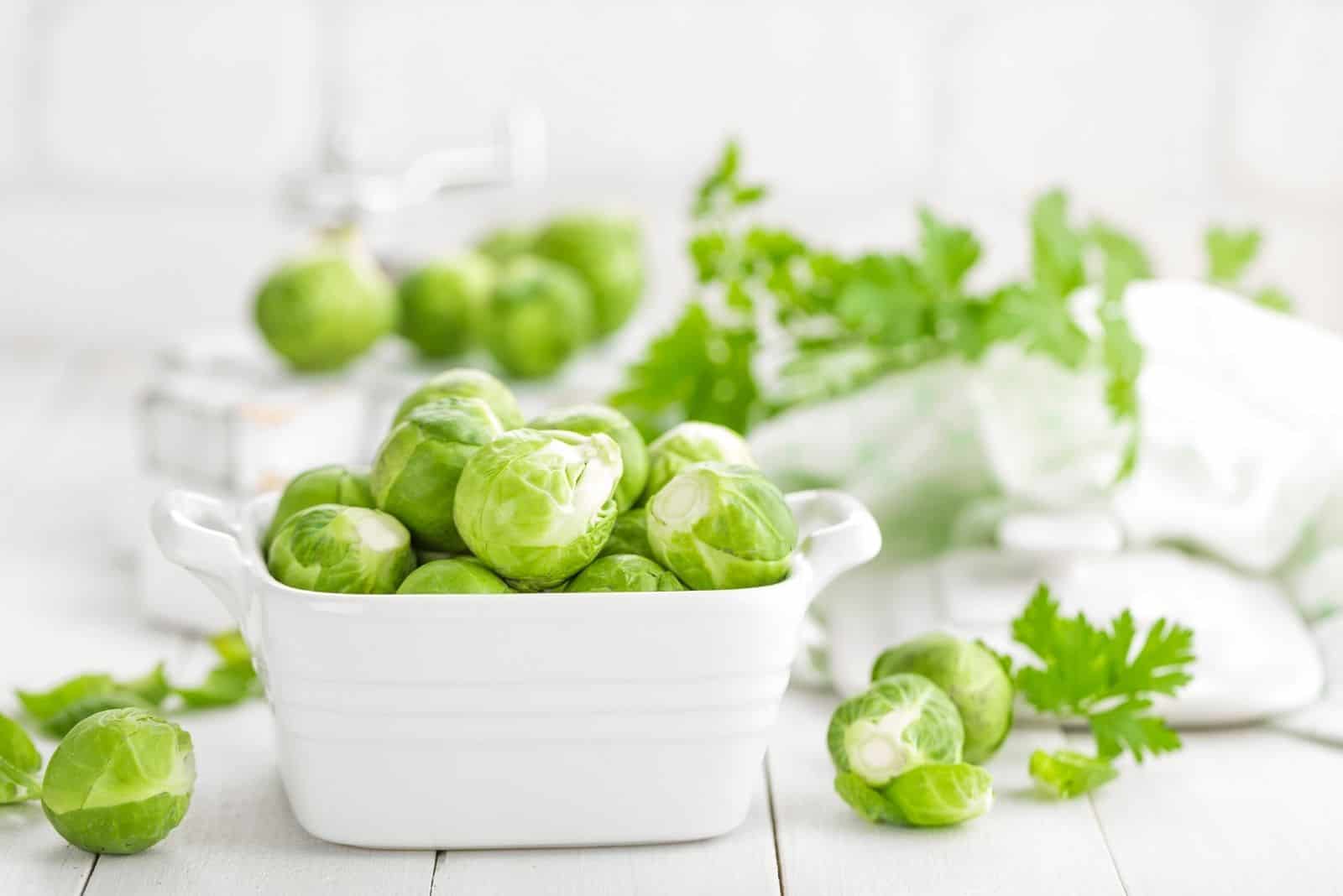 fresh brussel sprouts in a white square bowl