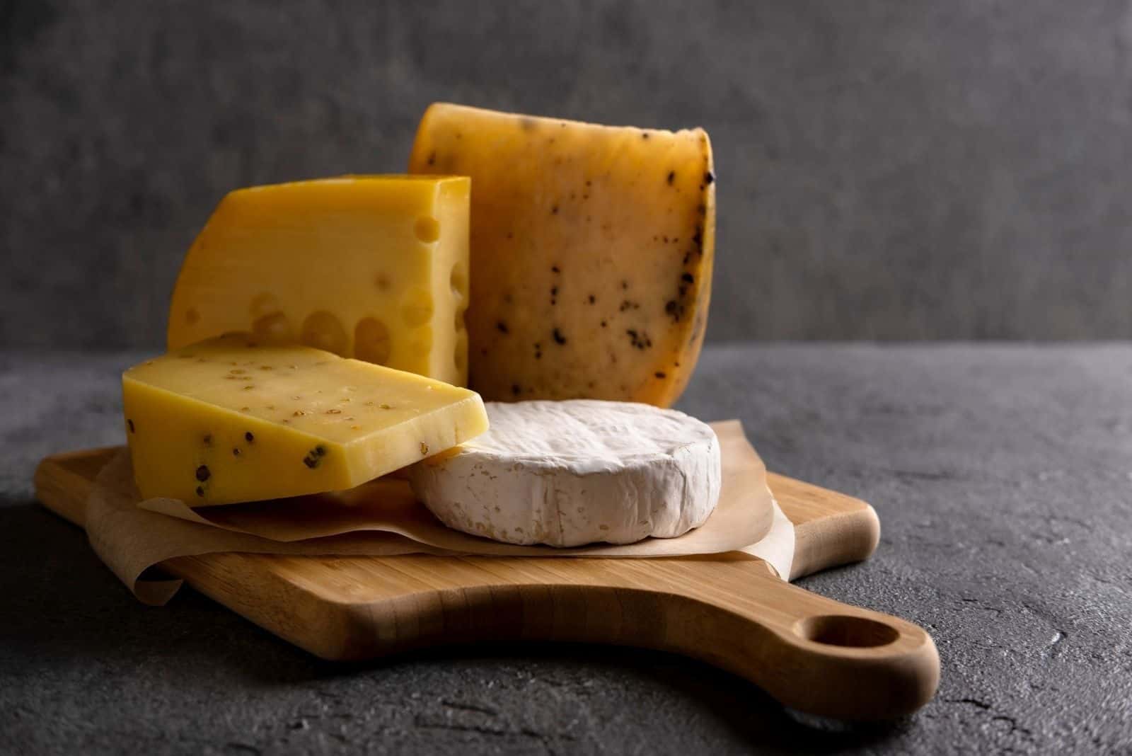 various types of cheese on the wooden board 