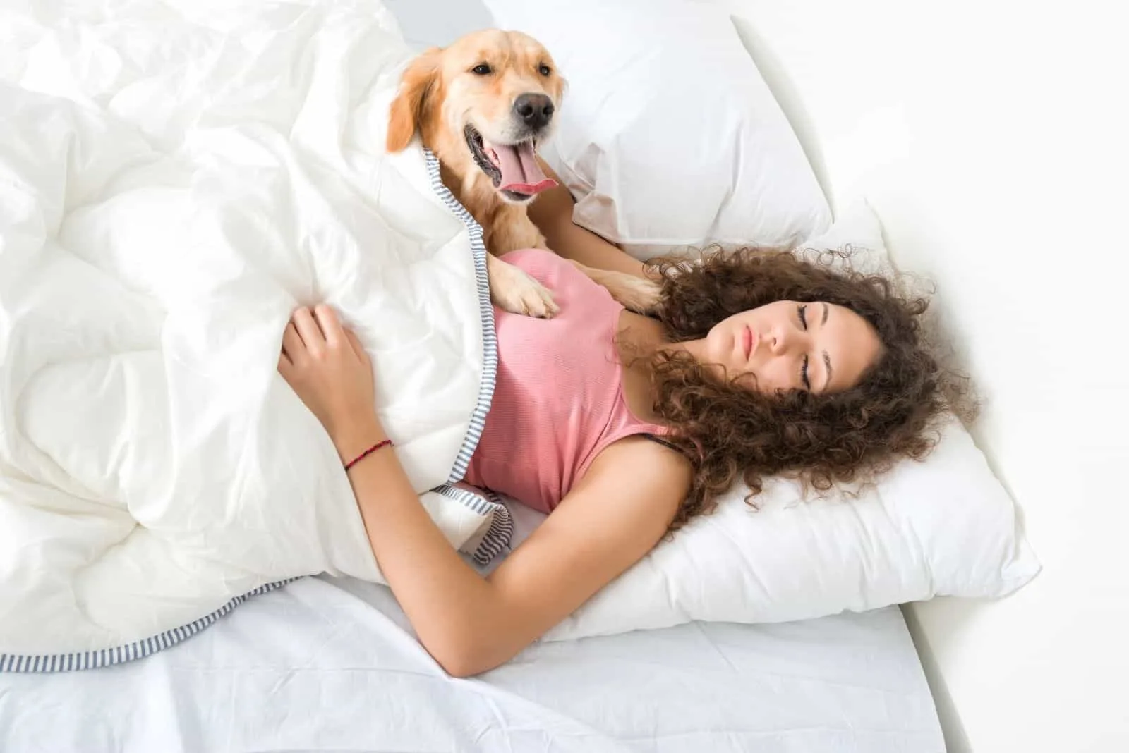 beautiful woman sleeping with her dog in bed