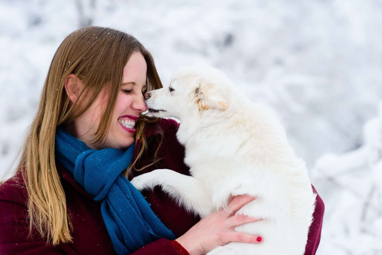 happy dog owner with the dog licking her nose