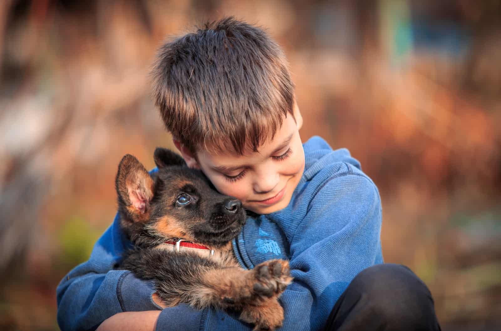 boy holding his german shepherd puppy