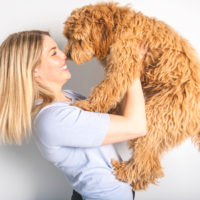 woman holding a goldendoodle pet