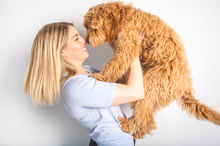 woman holding a goldendoodle pet