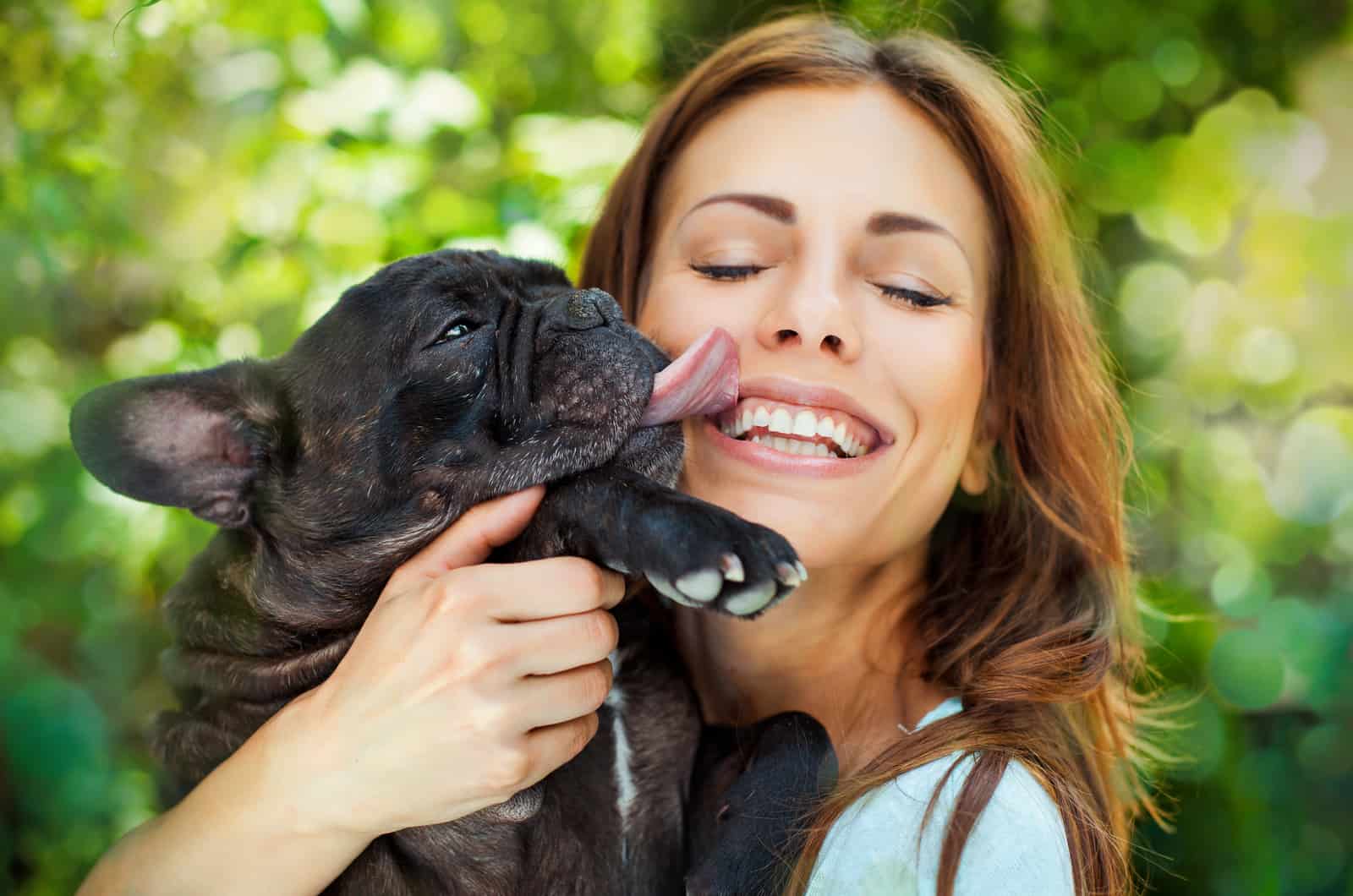 the dog licks the woman's face