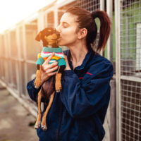 woman kissing her rescue dog