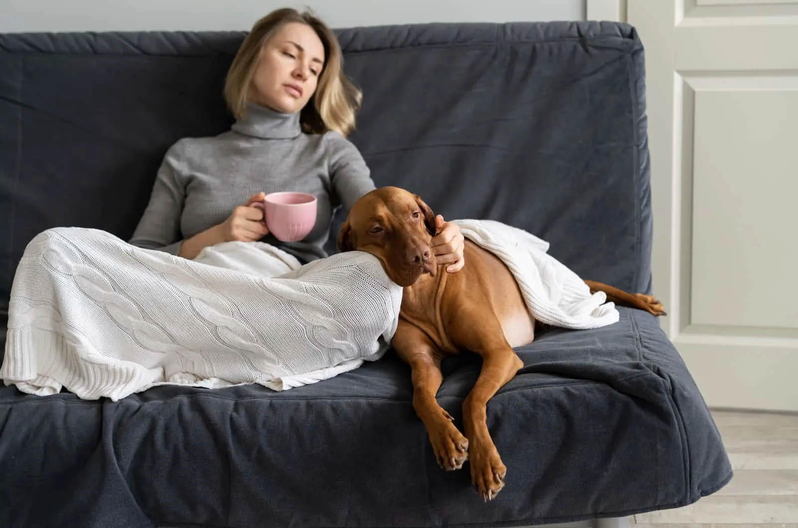sad woman and dog sitting on couch