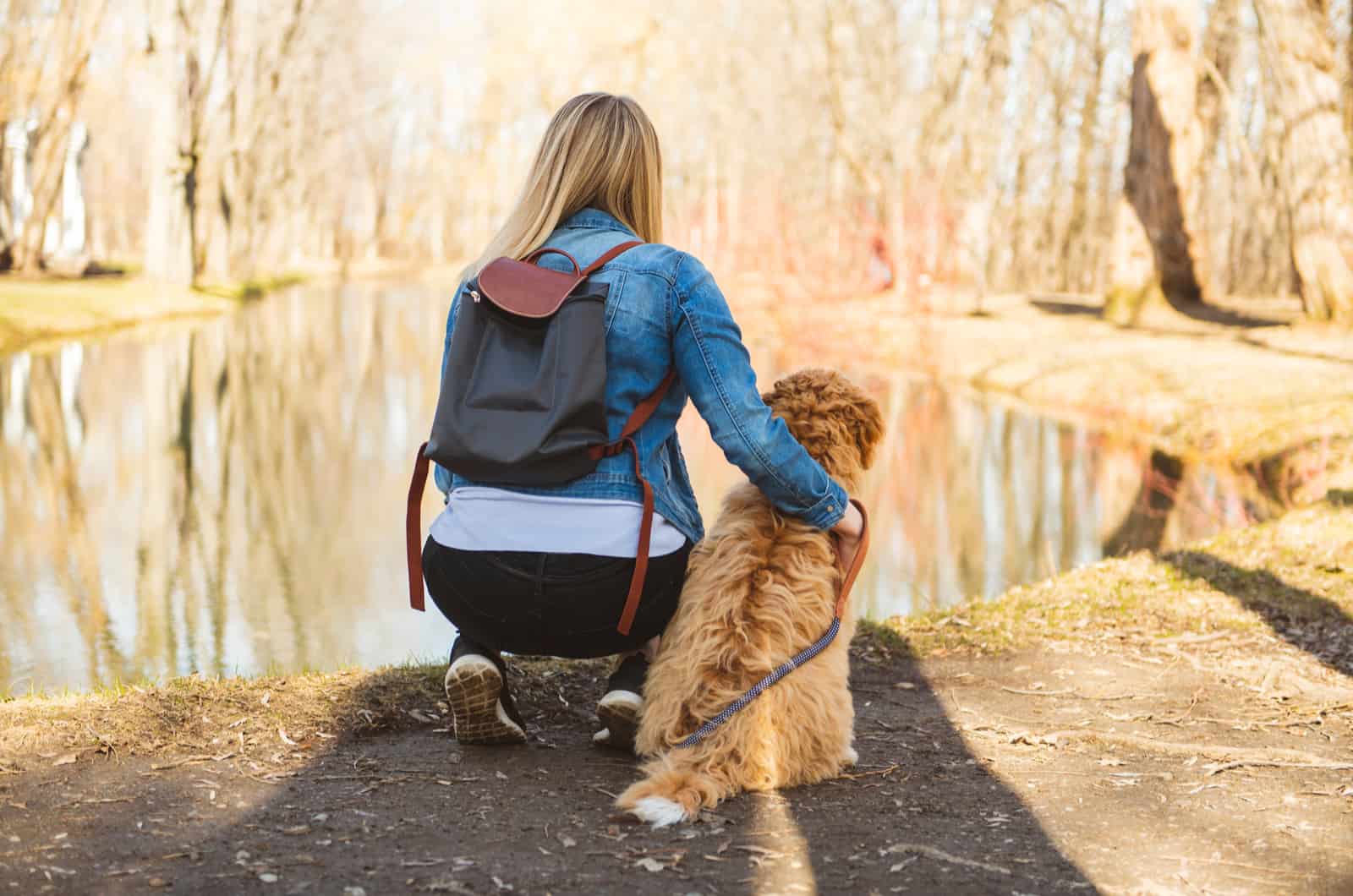 woman and dog by lake outside