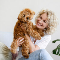 woman holding a toy poodle