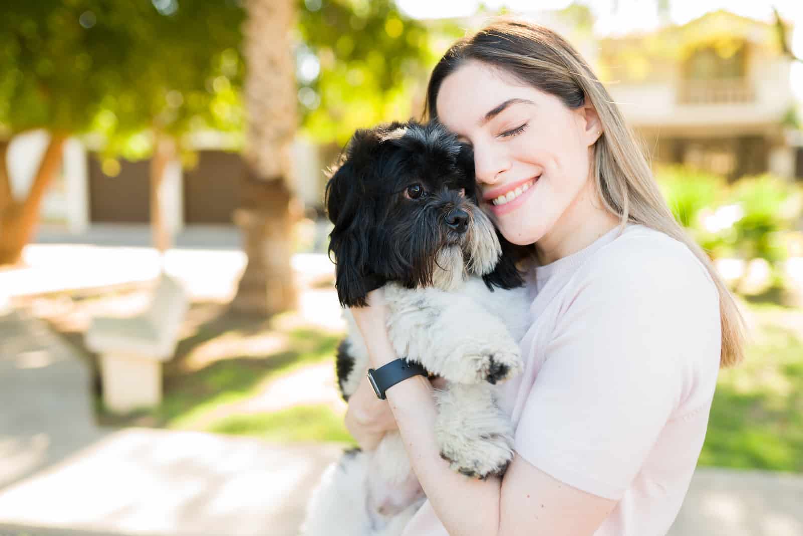 woman hugging her shih tzu pet