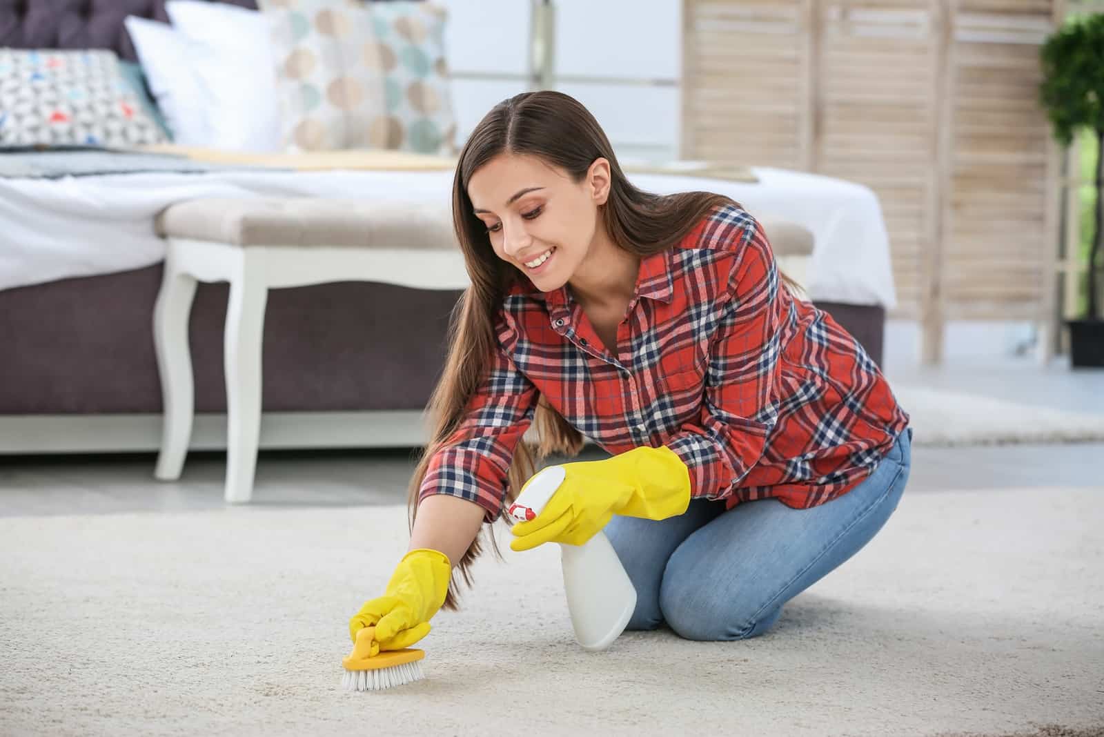 a smiling woman cleans the carpet