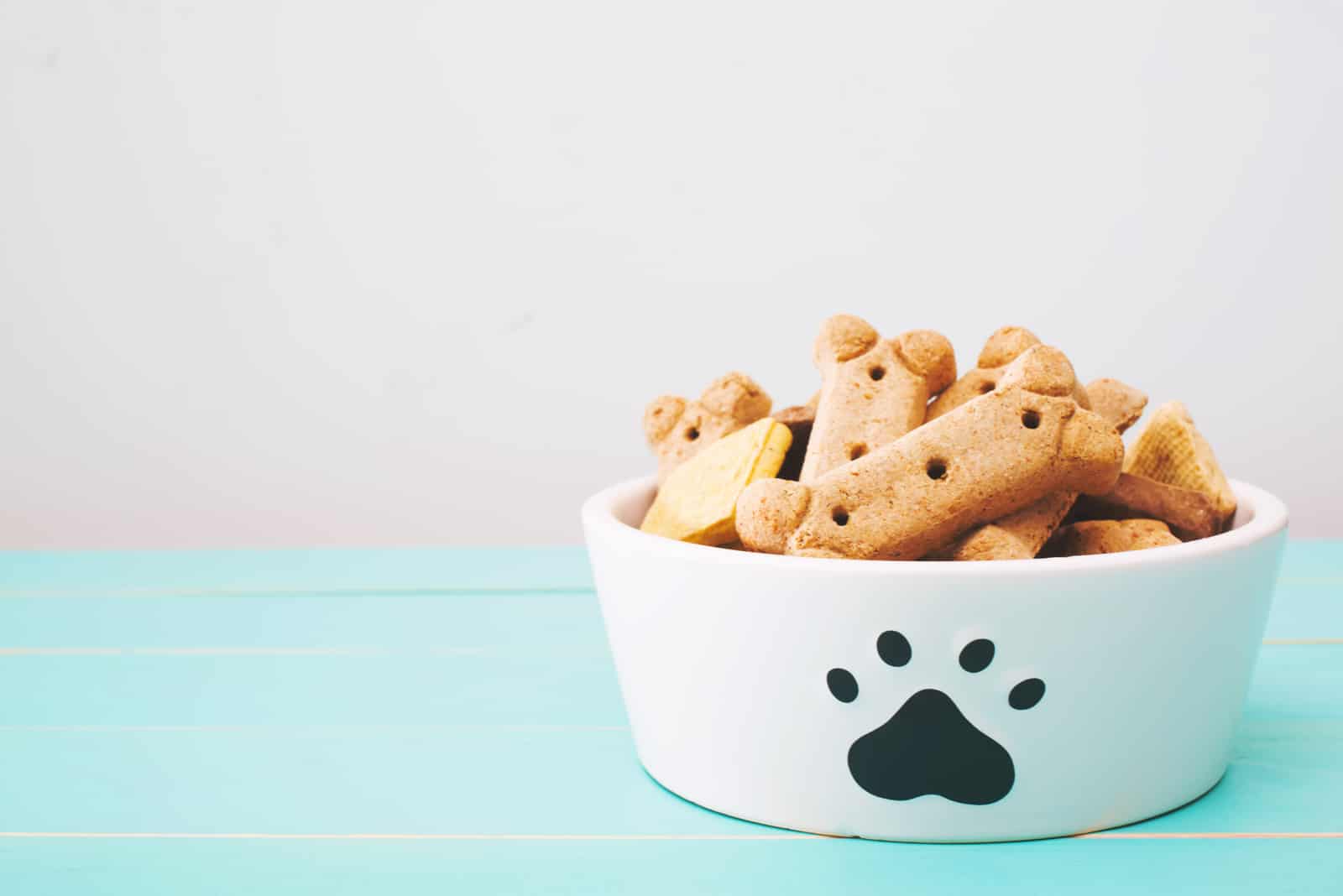 Dog treats in a bowl on wooden table