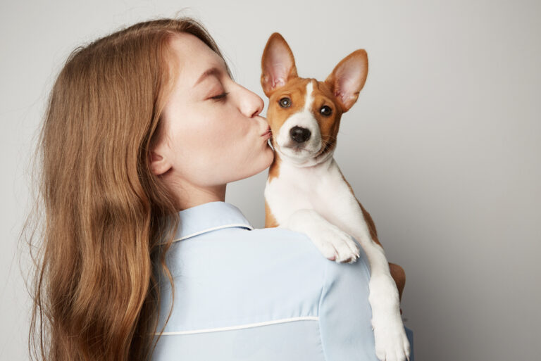girl kissing her basenji pet