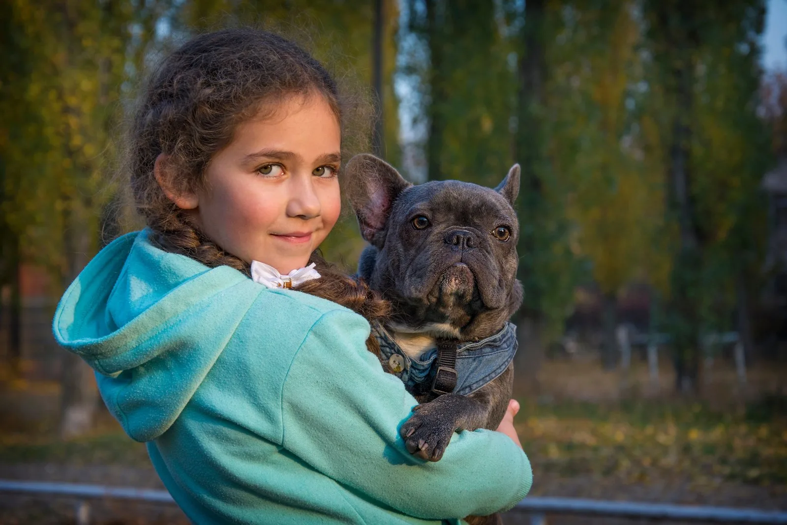 a beautiful girl holding a french bulldog