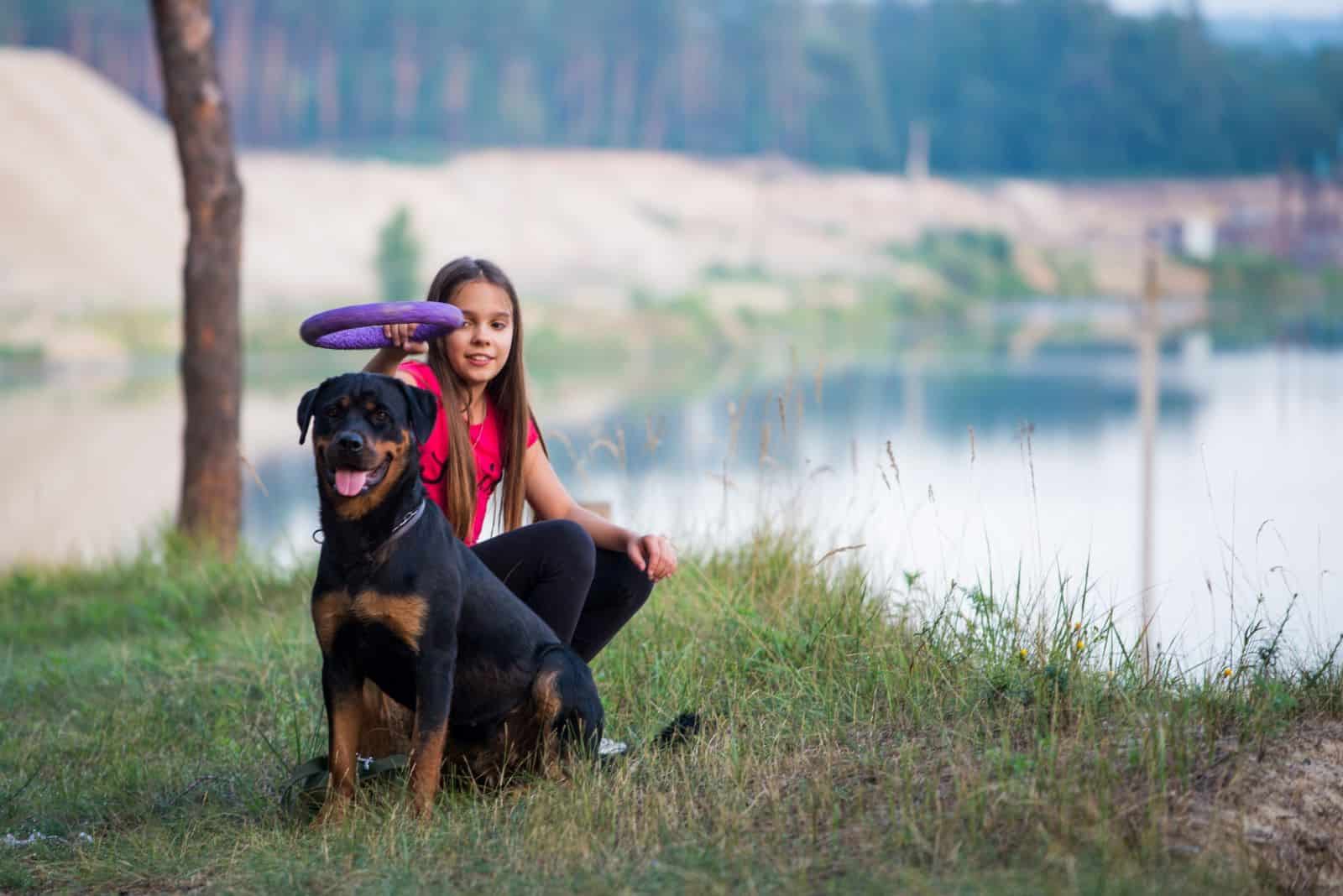 girl and rottweiler with a toy