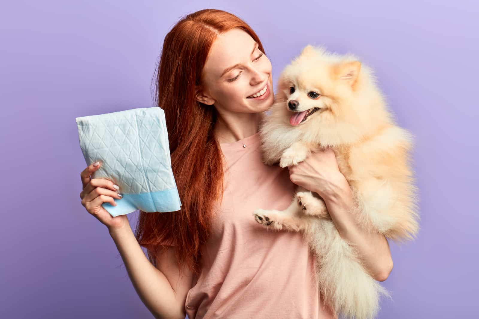woman holding dog and diapers