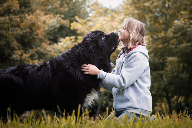 woman petting her newfoundland