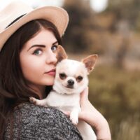 woman holding her chihuahua pet