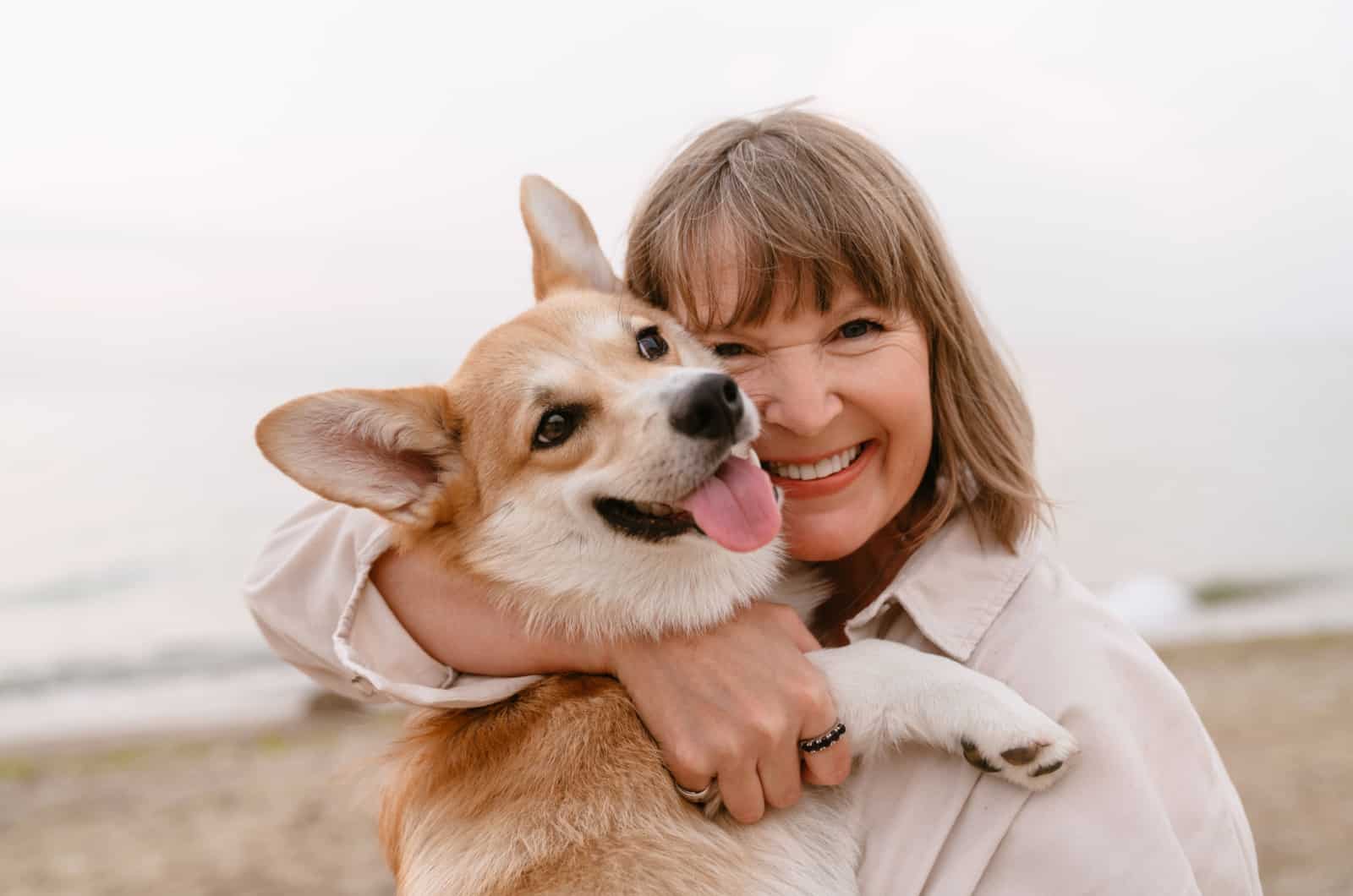 senior woman holding a corgi