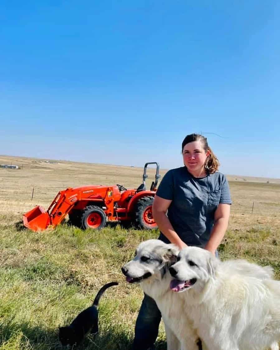 a woman stands with a Colorado Mountain Dog