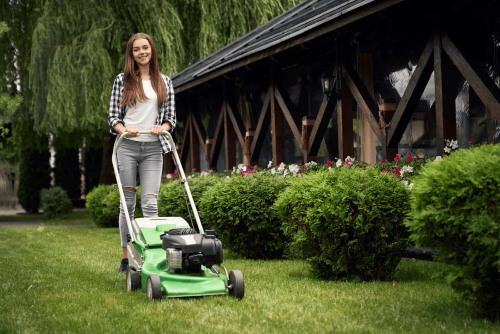 smiling girl mowing the lawn