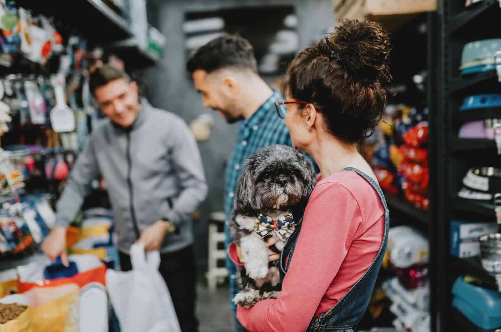 woman holding her dog while walking in store