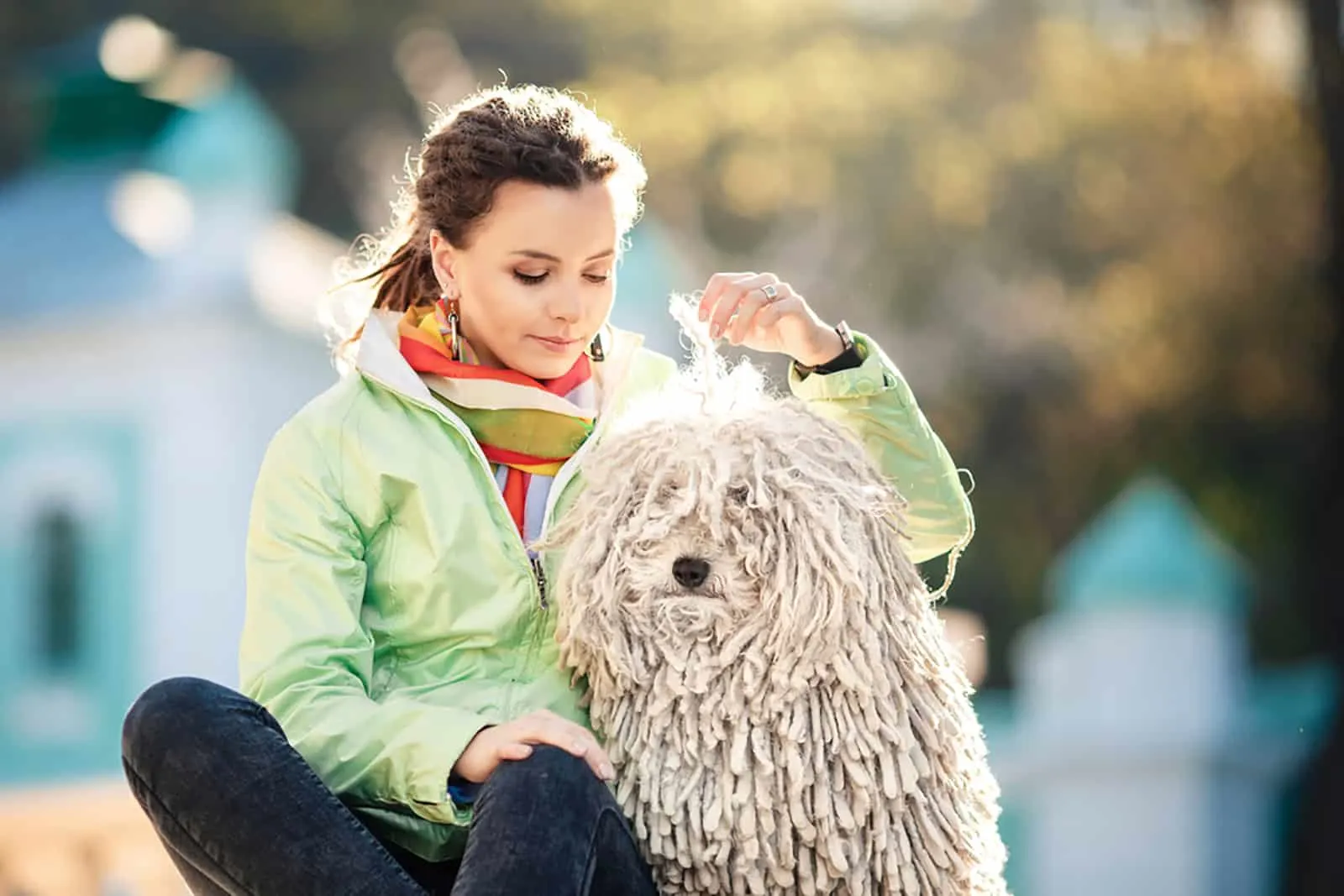 woman with puli dog sitting outdoors
