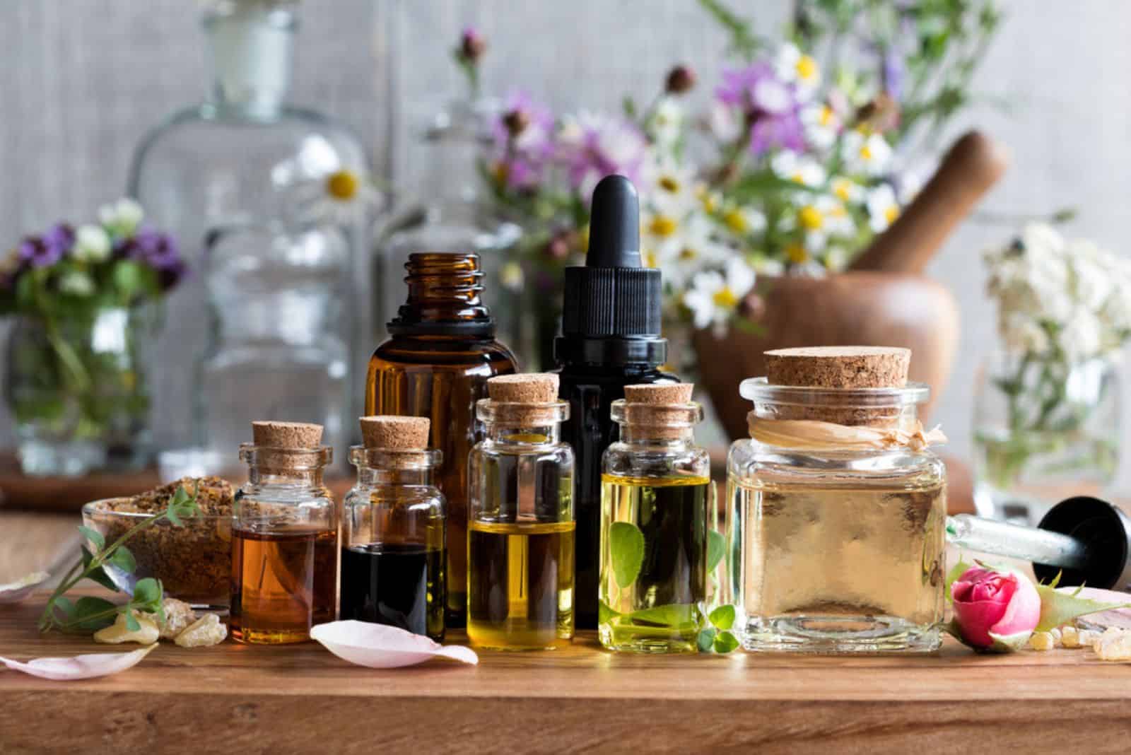 Selection of essential oils, with herbs and flowers
