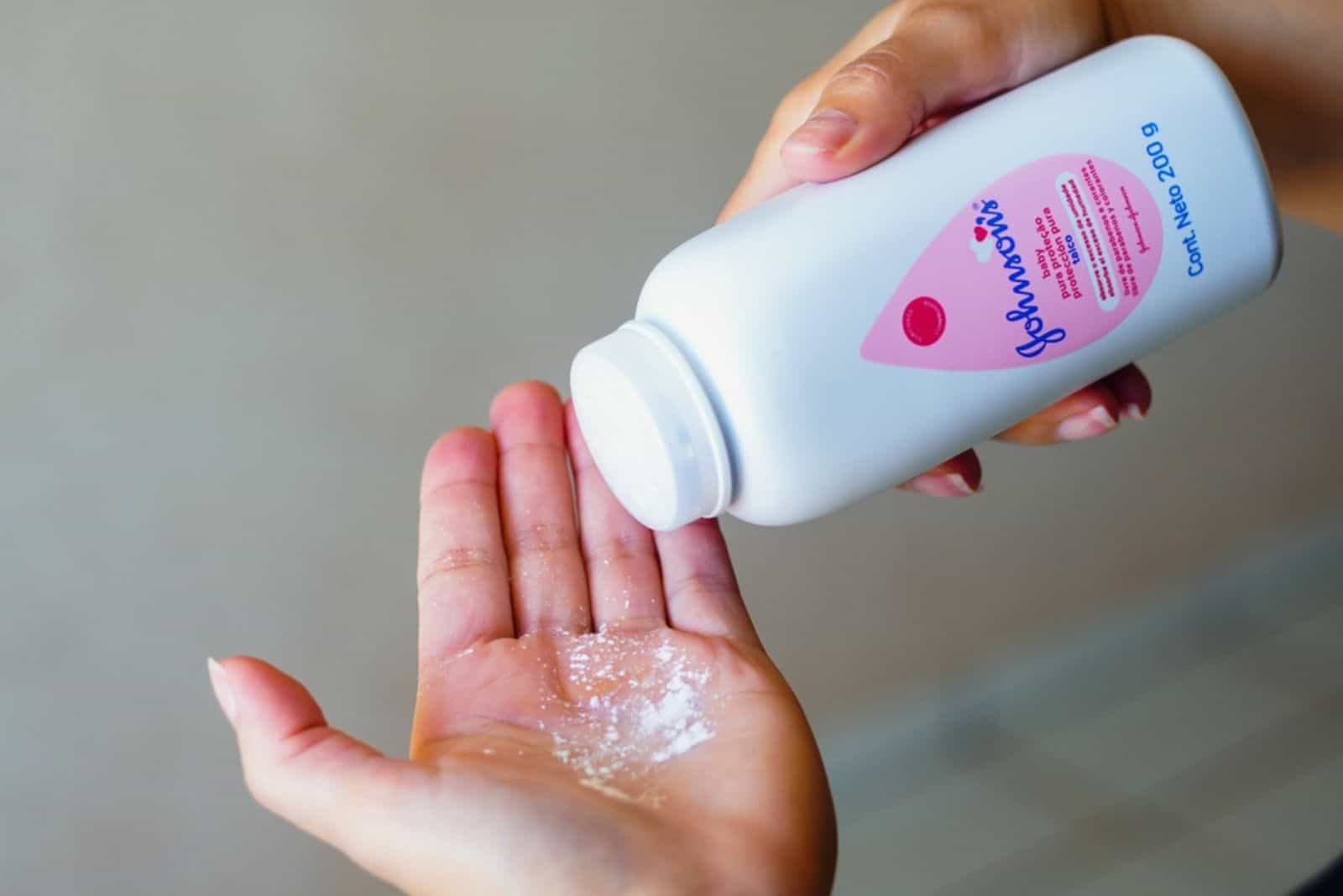 a woman puts baby powder on her hand