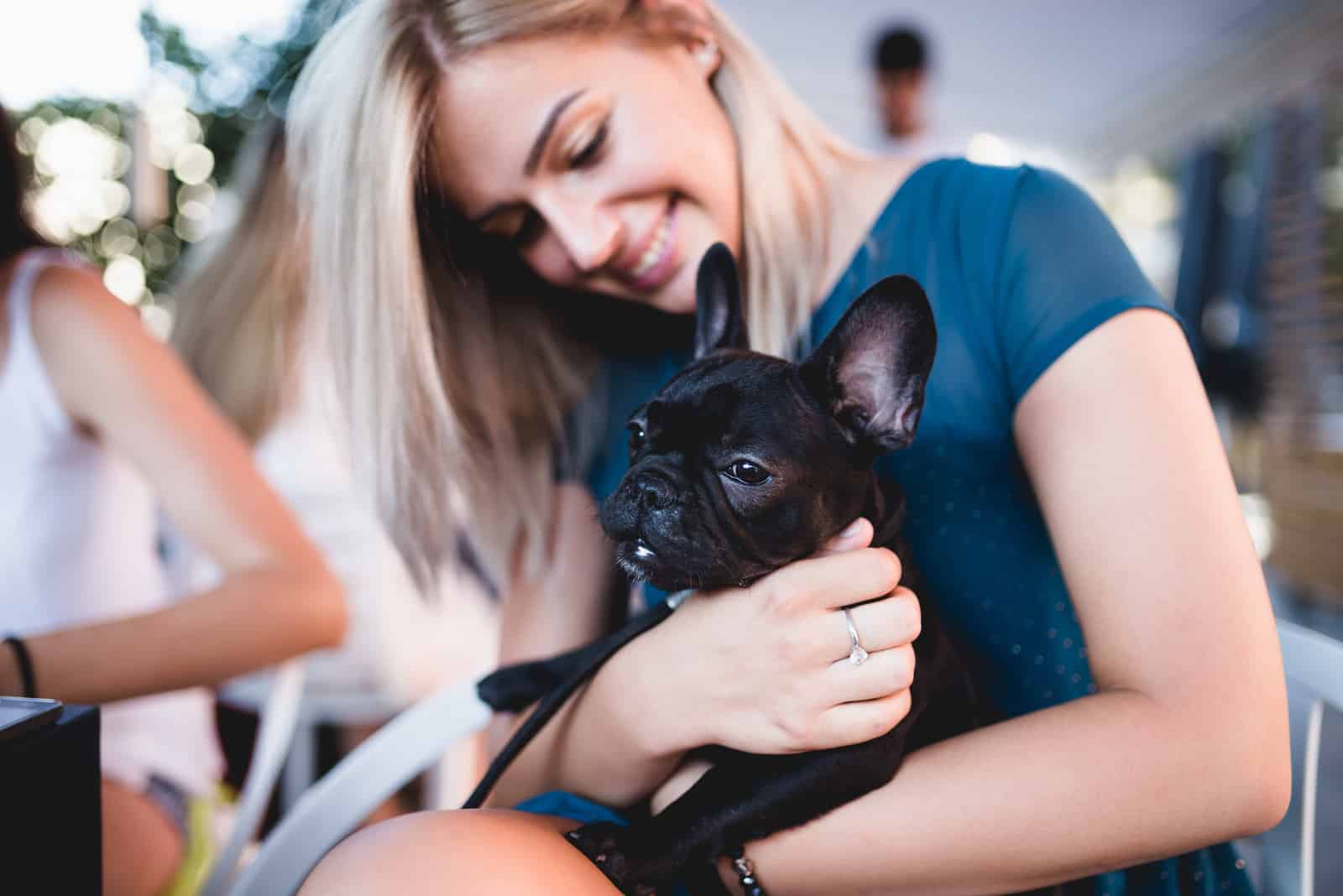 woman hugging her french bulldog puppy