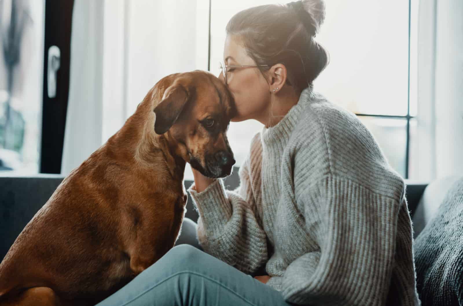 woman kissing her sick dog