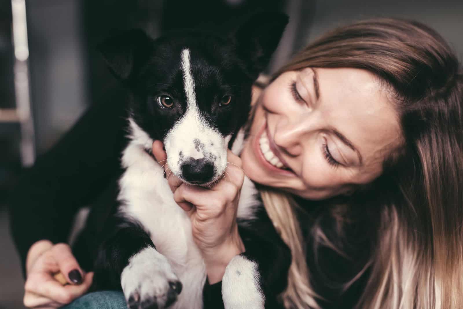 a smiling girl hugged a border collie