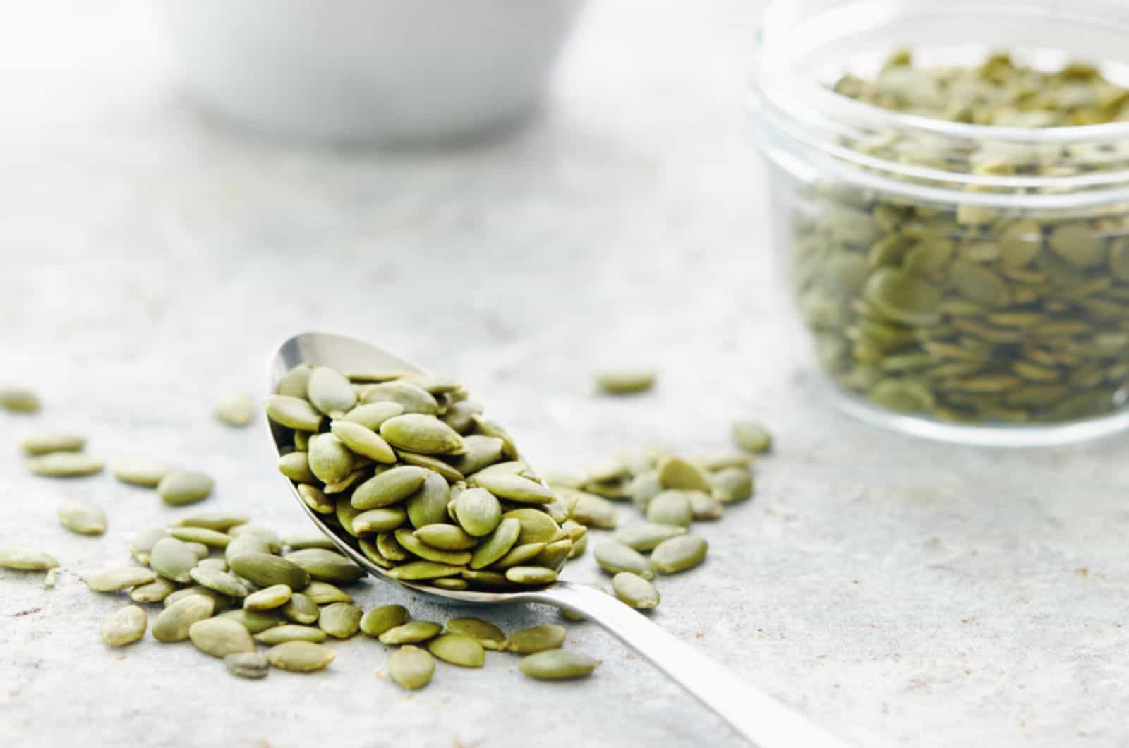 raw pumpkin seeds in a spoon